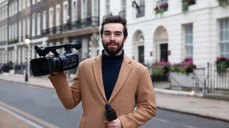 medium-shot-reporter-holding-video-camera medium-shot-reporter-holding-video-camera